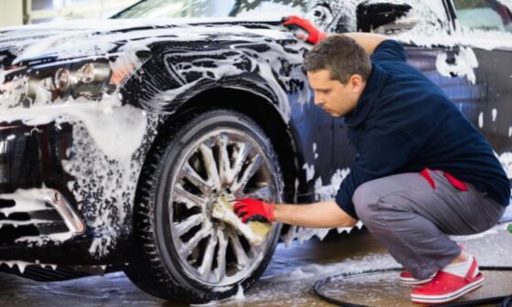 Mężczyzna myjący felgi pojazdu