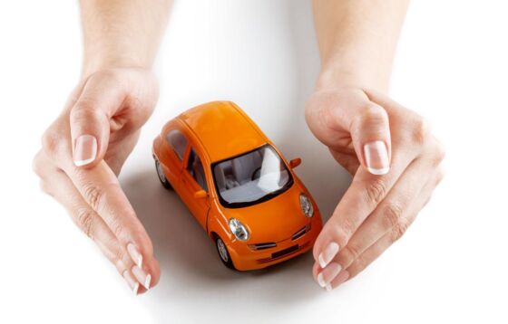 Zabawkowe auto chronione dłońmi